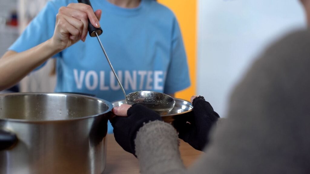 female volunteer filling a plate at a soup kitchen