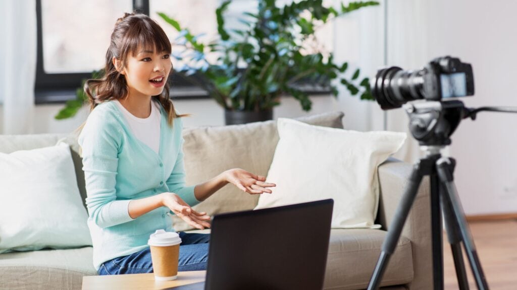 woman sitting on her couch recording a YouTube video