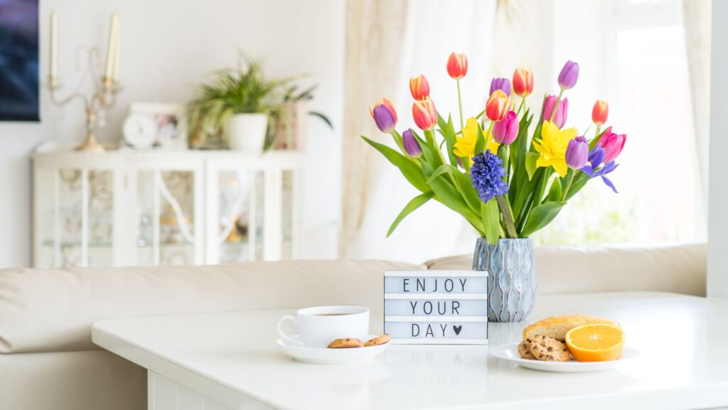 flowers and a sign that says enjoy your morning sitting on a table