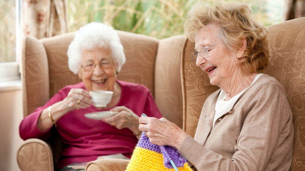 two elderly ladies sitting together and smiling